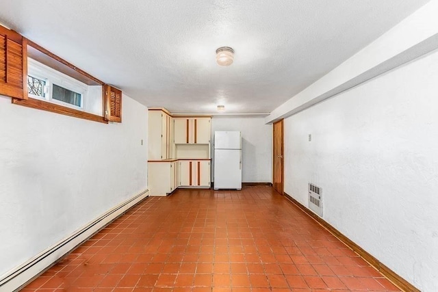 unfurnished room with a textured ceiling, heating unit, baseboards, and a baseboard radiator