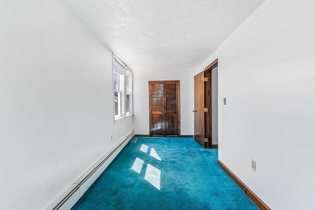 interior space featuring carpet flooring, a textured ceiling, baseboards, and a baseboard radiator