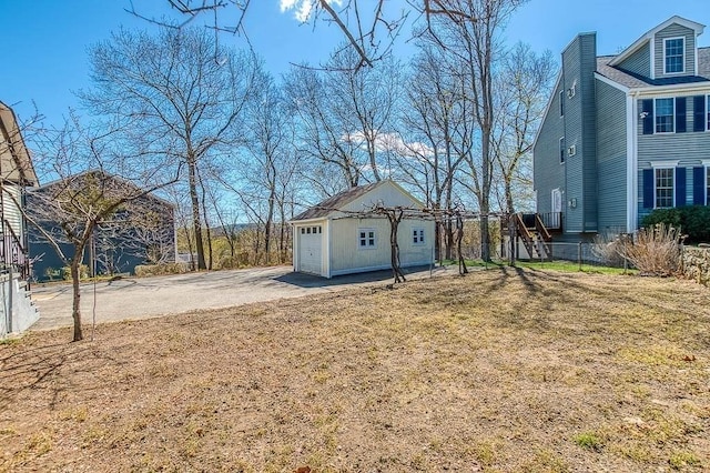 exterior space with a detached garage, driveway, and an outdoor structure