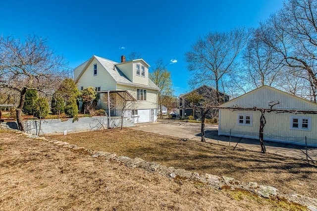 view of side of home featuring a chimney and an attached garage