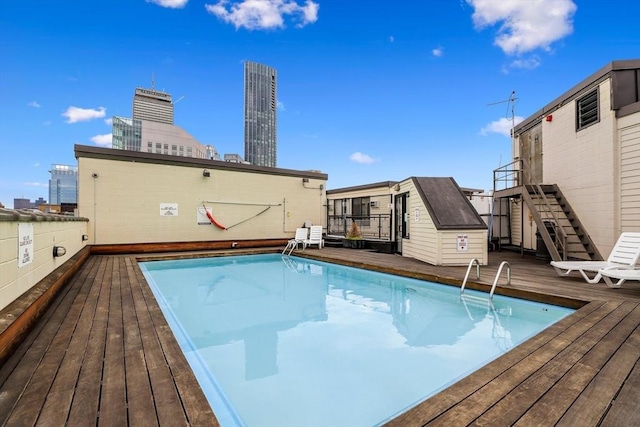 view of swimming pool with a deck and a storage unit