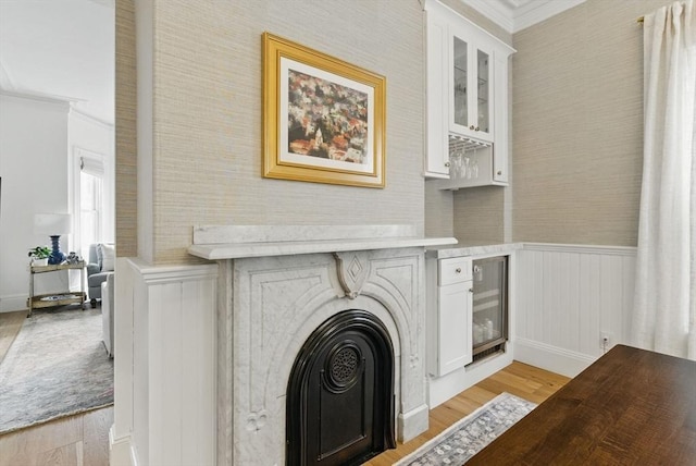 782 E 4th St, Boston, MA 02127 - detailed view of wood finished floors, wine cooler, crown molding, a wainscoted wall, and a dry bar