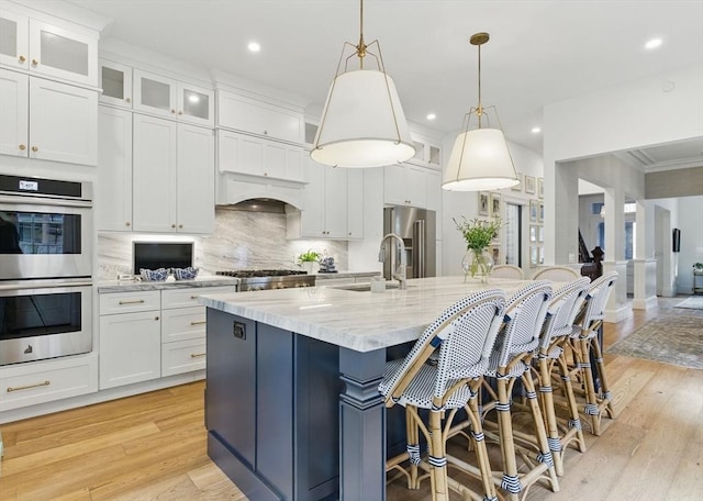 782 E 4th St, Boston, MA 02127 - kitchen featuring appliances with stainless steel finishes, light wood-style floors, decorative backsplash, white cabinets, and recessed lighting