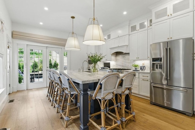 782 E 4th St, Boston, MA 02127 - kitchen featuring high end refrigerator, recessed lighting, light wood finished floors, a breakfast bar, and decorative backsplash