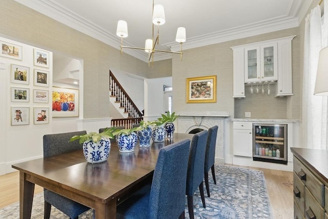782 E 4th St, Boston, MA 02127 - dining room with beverage cooler, a chandelier, light wood-type flooring, ornamental molding, and stairs