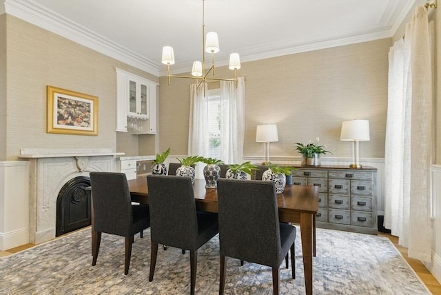 782 E 4th St, Boston, MA 02127 - dining area with wallpapered walls, light wood-style floors, ornamental molding, a wainscoted wall, and a premium fireplace