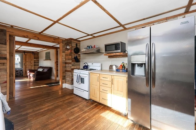 kitchen with appliances with stainless steel finishes, dark hardwood / wood-style floors, light brown cabinets, and wooden walls