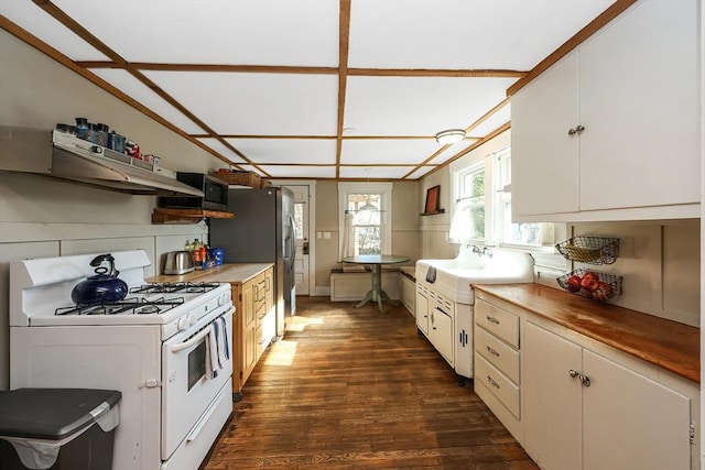 kitchen featuring white cabinetry, dark wood-type flooring, butcher block countertops, and gas range gas stove