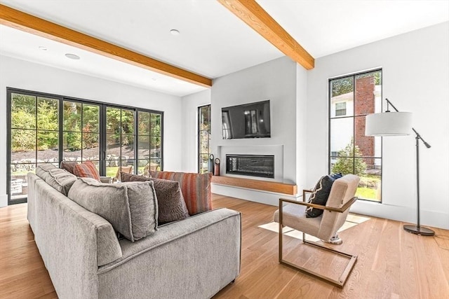 living room featuring beam ceiling and light wood-type flooring