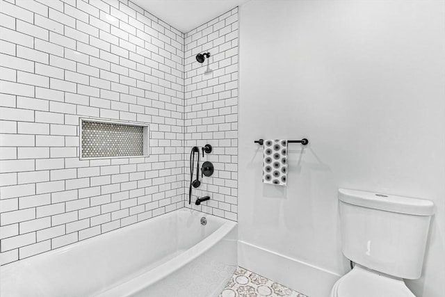 bathroom with tiled shower / bath, tile patterned floors, and toilet