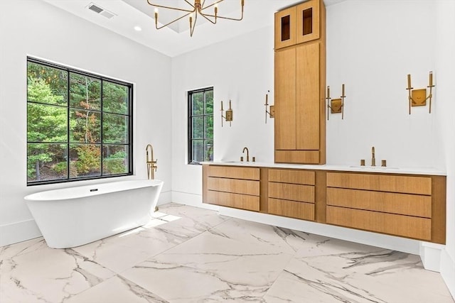 bathroom with vanity, a washtub, and an inviting chandelier