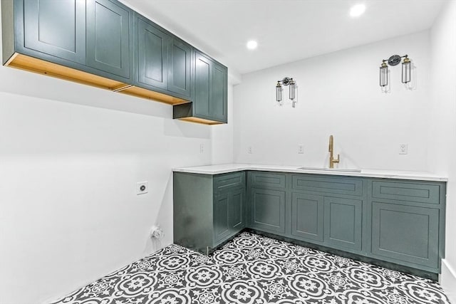 laundry area with cabinets, electric dryer hookup, sink, and light tile patterned floors