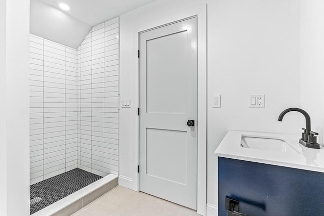 bathroom featuring tile patterned flooring, vanity, and tiled shower