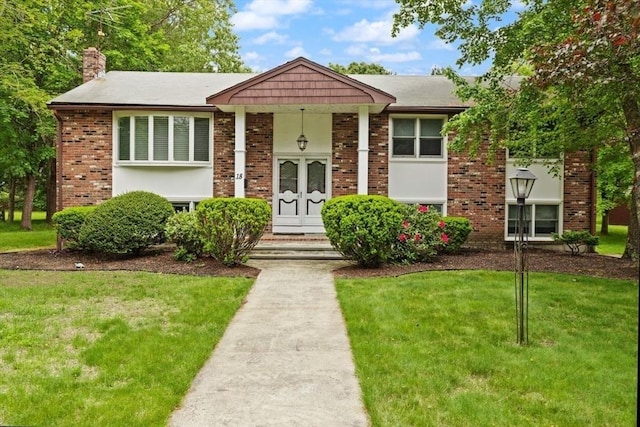 18 Sunset Dr, Sharon, MA 02067 - view of front of property featuring a front lawn, brick siding, and a chimney