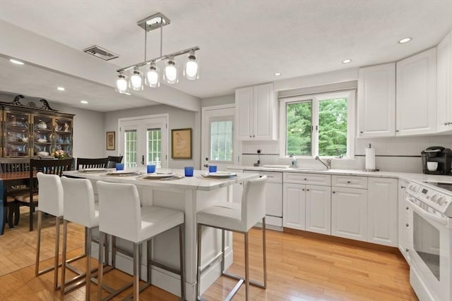 18 Sunset Dr, Sharon, MA 02067 - kitchen featuring white appliances, a breakfast bar, light countertops, and recessed lighting