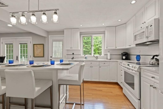 18 Sunset Dr, Sharon, MA 02067 - kitchen with white appliances, a breakfast bar, tasteful backsplash, light countertops, and white cabinetry