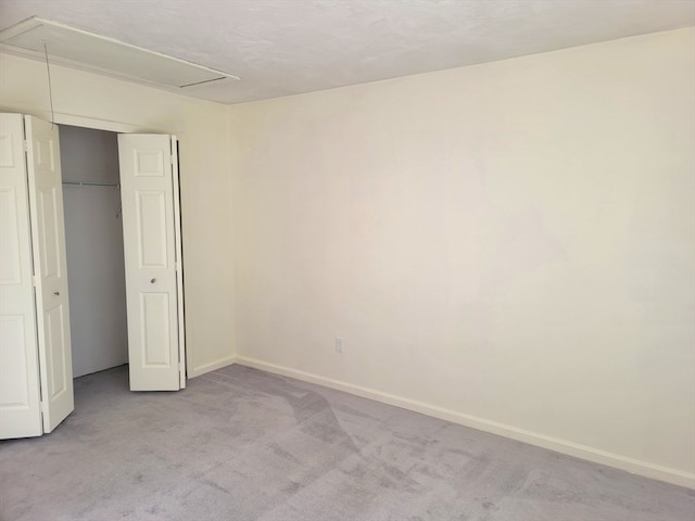 unfurnished bedroom with a closet and light colored carpet