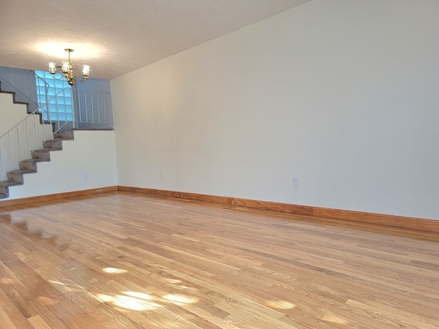 interior space with a textured ceiling, an inviting chandelier, and light hardwood / wood-style flooring