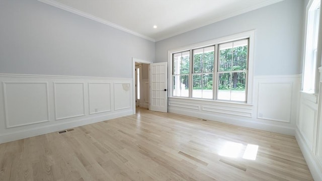 784 Main St, Hudson, MA 01749 - empty room featuring a decorative wall, light wood-style flooring, ornamental molding, and a wainscoted wall