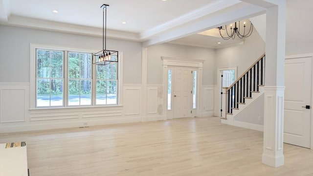 784 Main St, Hudson, MA 01749 - foyer featuring a chandelier, a decorative wall, light wood finished floors, stairway, and wainscoting
