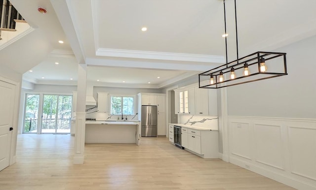 784 Main St, Hudson, MA 01749 - kitchen with high end refrigerator, wine cooler, light wood-style flooring, crown molding, and light countertops