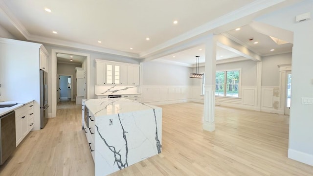 784 Main St, Hudson, MA 01749 - kitchen featuring stainless steel appliances, white cabinets, light stone countertops, light wood-style flooring, and wainscoting