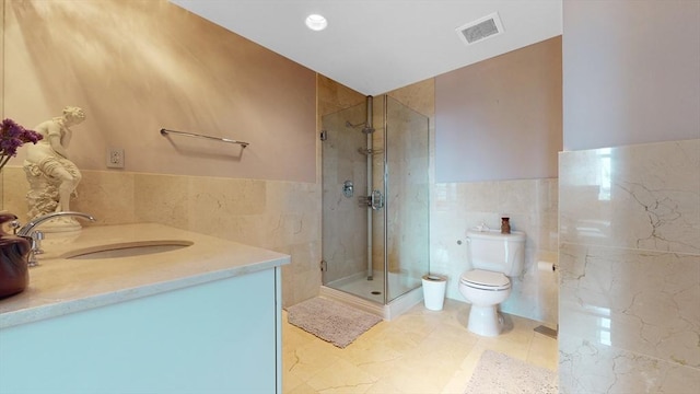 bathroom with vanity, visible vents, a shower stall, tile walls, and toilet