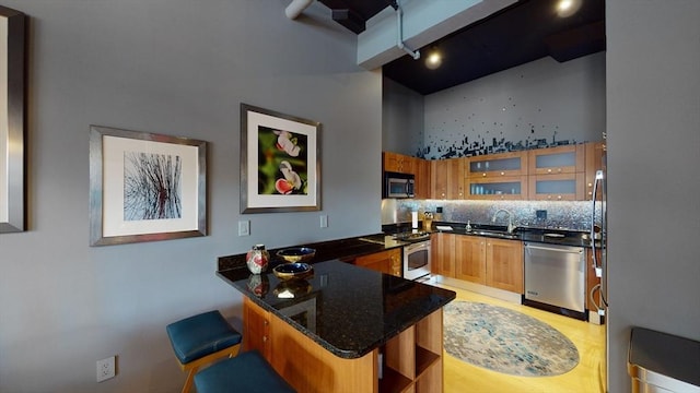 kitchen featuring tasteful backsplash, a sink, appliances with stainless steel finishes, a peninsula, and open shelves