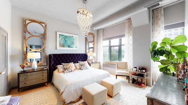 bedroom featuring visible vents, an inviting chandelier, and wood finished floors