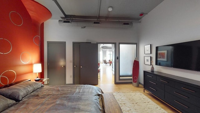 bedroom featuring visible vents, two closets, and light wood-style flooring