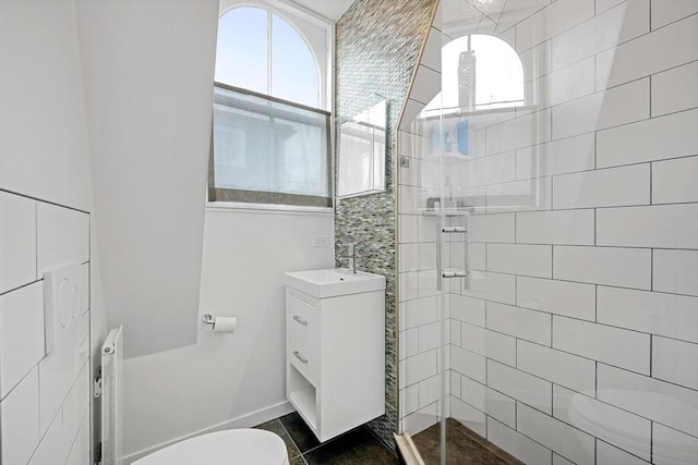 bathroom with vanity, toilet, radiator, and a shower with door