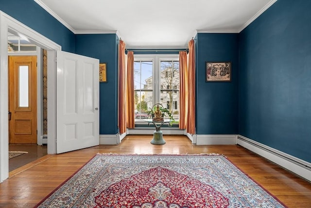 entryway featuring hardwood / wood-style floors, crown molding, and a baseboard radiator