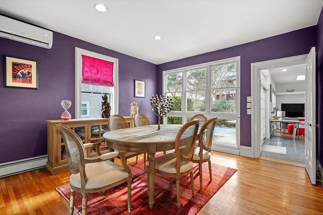 dining area featuring light hardwood / wood-style flooring, an AC wall unit, and a baseboard radiator