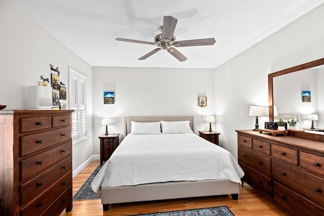 bedroom featuring baseboards, a ceiling fan, and light wood finished floors