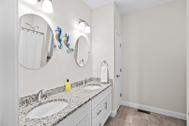 full bath with a sink, baseboards, double vanity, and visible vents