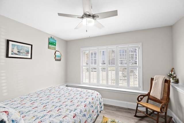 bedroom featuring baseboards, a ceiling fan, and wood finished floors