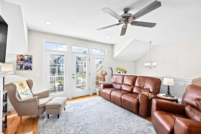 living area featuring ceiling fan with notable chandelier, french doors, recessed lighting, and wood finished floors