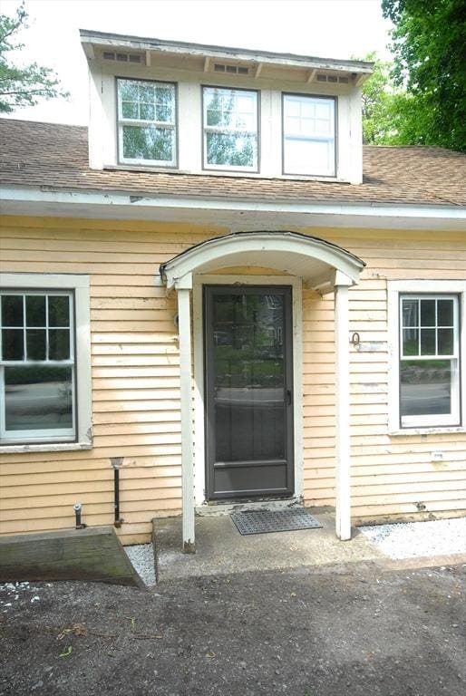 100 Main, Acton, MA 01720 - doorway to property featuring roof with shingles