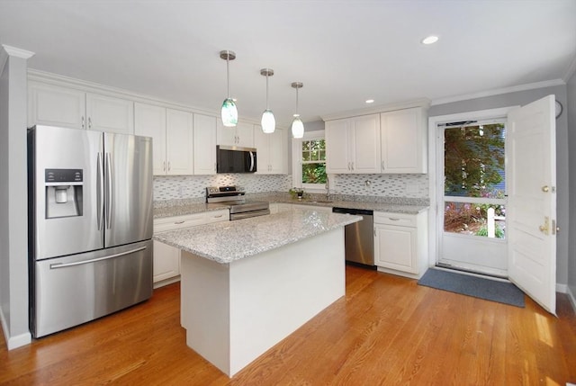 100 Main, Acton, MA 01720 - kitchen with appliances with stainless steel finishes, white cabinetry, decorative backsplash, decorative light fixtures, and light wood-type flooring