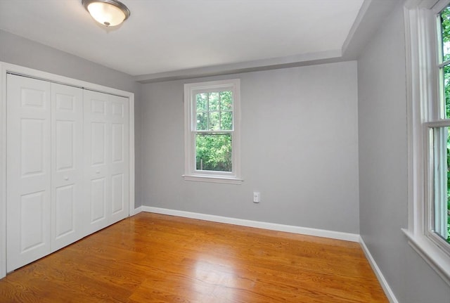 100 Main, Acton, MA 01720 - unfurnished bedroom with multiple windows, wood finished floors, and baseboards