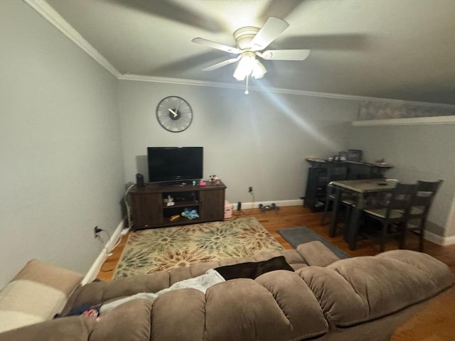 living room featuring ornamental molding, a ceiling fan, baseboards, and wood finished floors