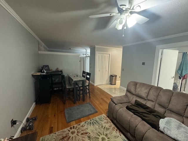 living room with baseboards, ornamental molding, and wood finished floors