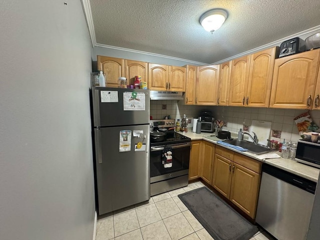 kitchen featuring light tile patterned floors, tasteful backsplash, appliances with stainless steel finishes, under cabinet range hood, and a sink