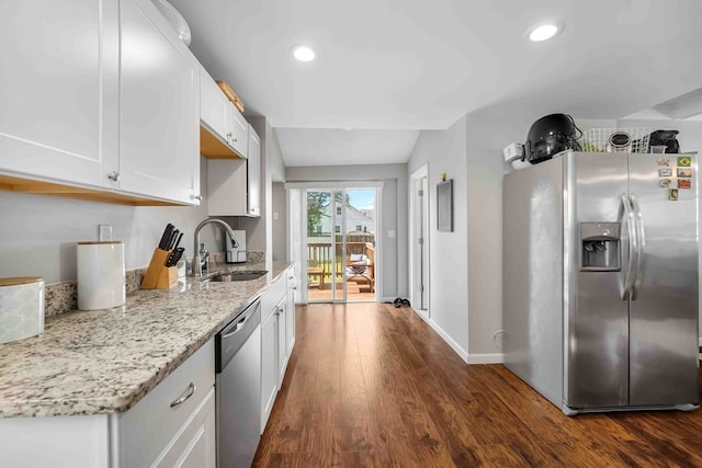 kitchen with dark wood-type flooring, sink, white cabinets, appliances with stainless steel finishes, and light stone countertops