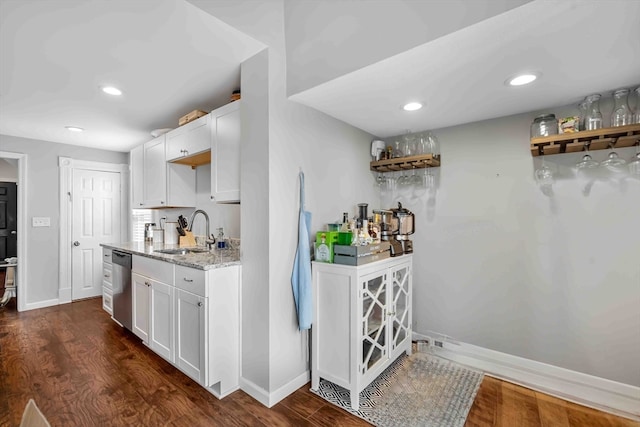 bar featuring light stone counters, sink, white cabinetry, dishwasher, and dark hardwood / wood-style flooring