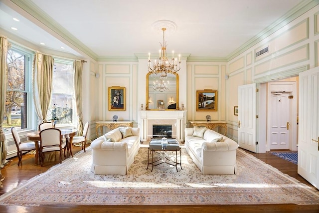 living area featuring a healthy amount of sunlight, dark wood-type flooring, and crown molding