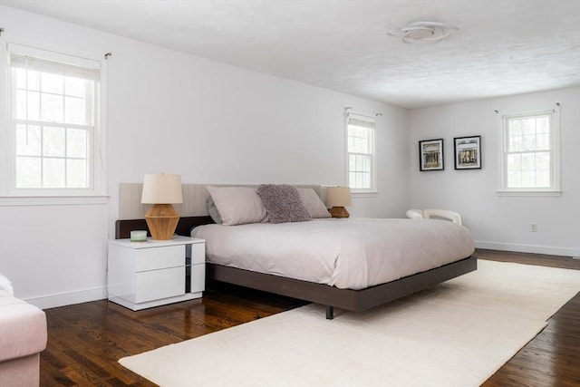 bedroom featuring dark wood finished floors and baseboards