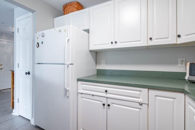 1 Riverview Blvd Unit 2-213, Methuen, MA 01844 - kitchen with freestanding refrigerator, white cabinets, wood finished floors, and dark countertops