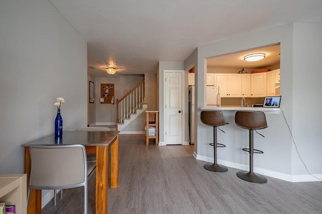 1 Riverview Blvd Unit 2-213, Methuen, MA 01844 - kitchen with a kitchen bar, wood finished floors, baseboards, white cabinetry, and a sink