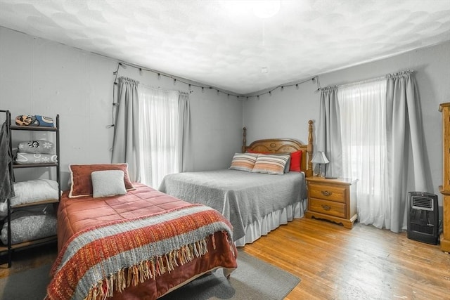 bedroom with light wood finished floors and heating unit